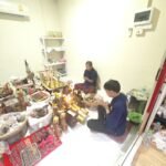 Phu Lersi Pong and Ajarn Mee performing consecration ritual with candles, offerings, and sacred materials for amulet blessing
