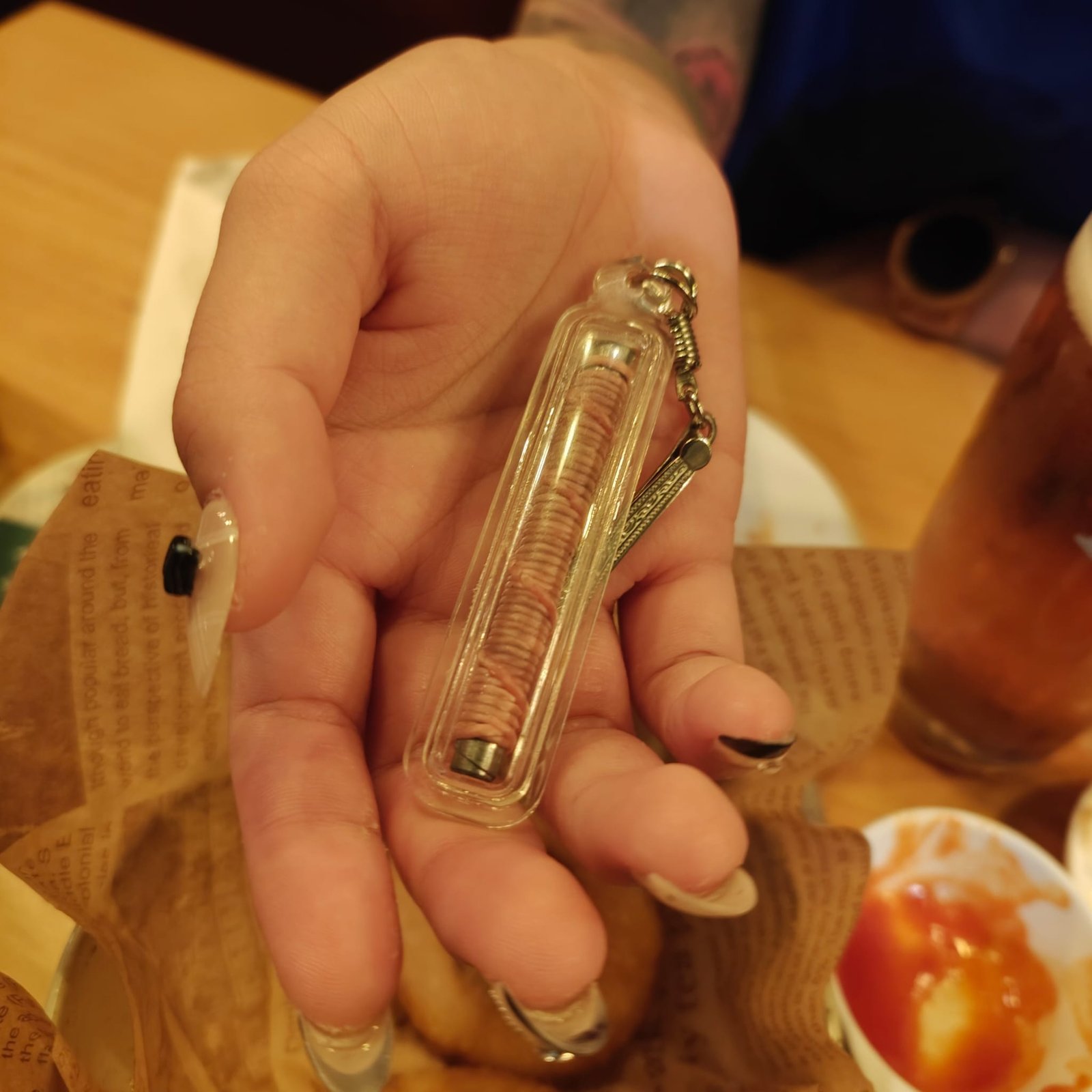 Takrut Bua Bang Bai Na Ok Tek held in hand during real-life use as an old saneh charm takrut