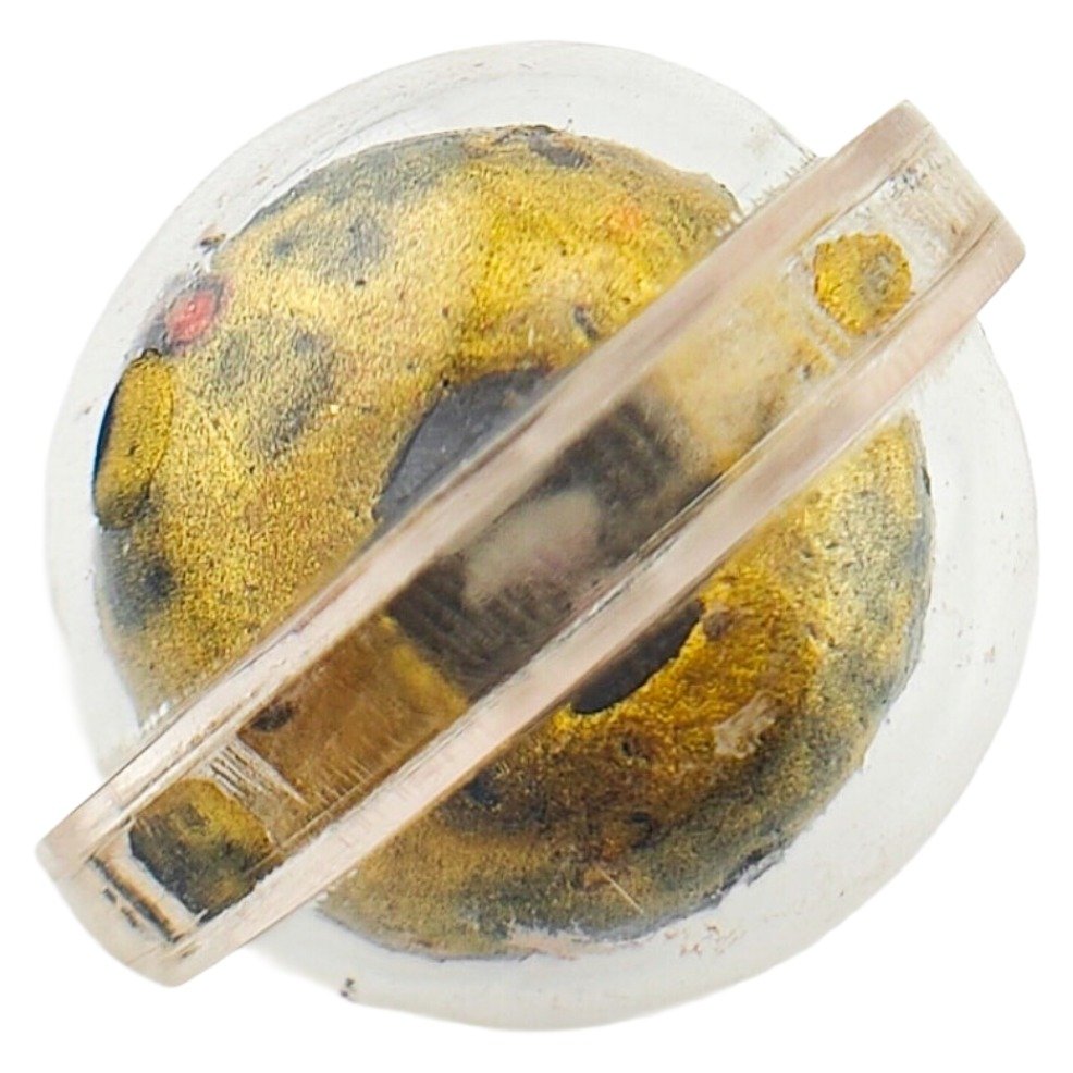 Close side view of 9 Mae Relic Loop Om showing the 9 mae prai relic inside the casing.