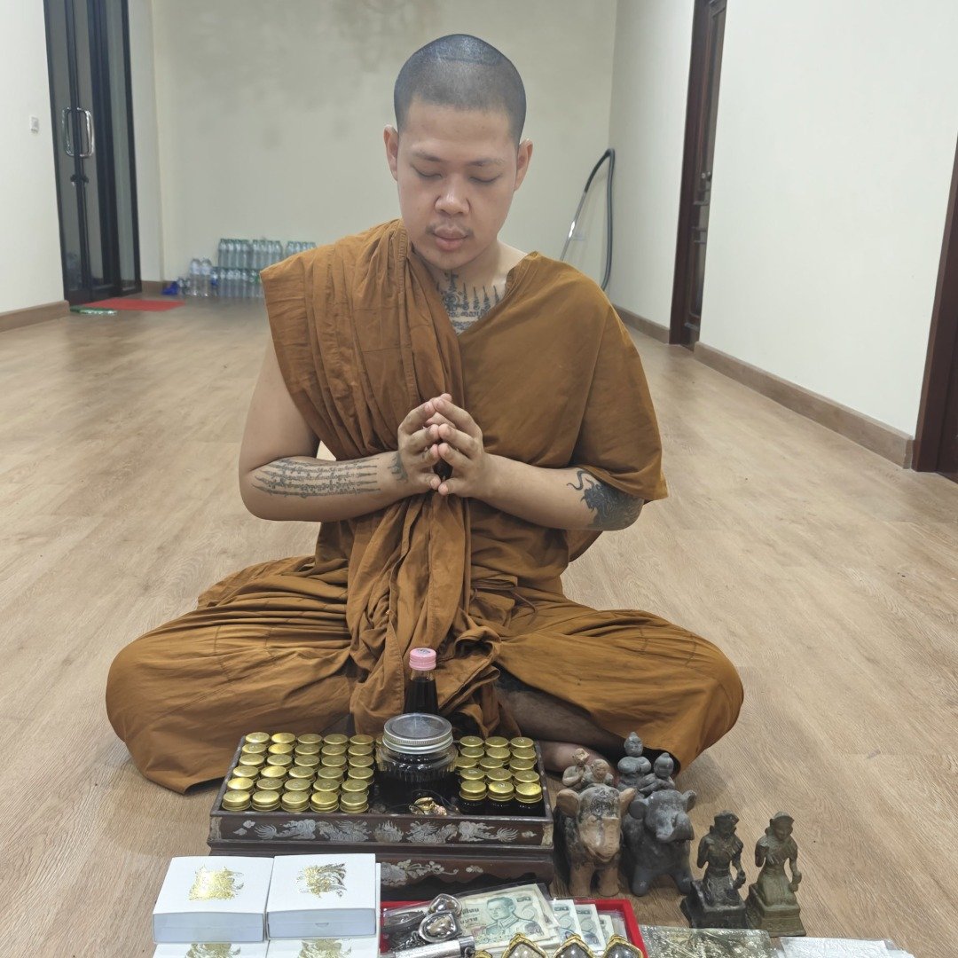 Kruba Thep chanting over spiritual items with the personal pair of Nang Kwak placed nearby during the blessing ceremony