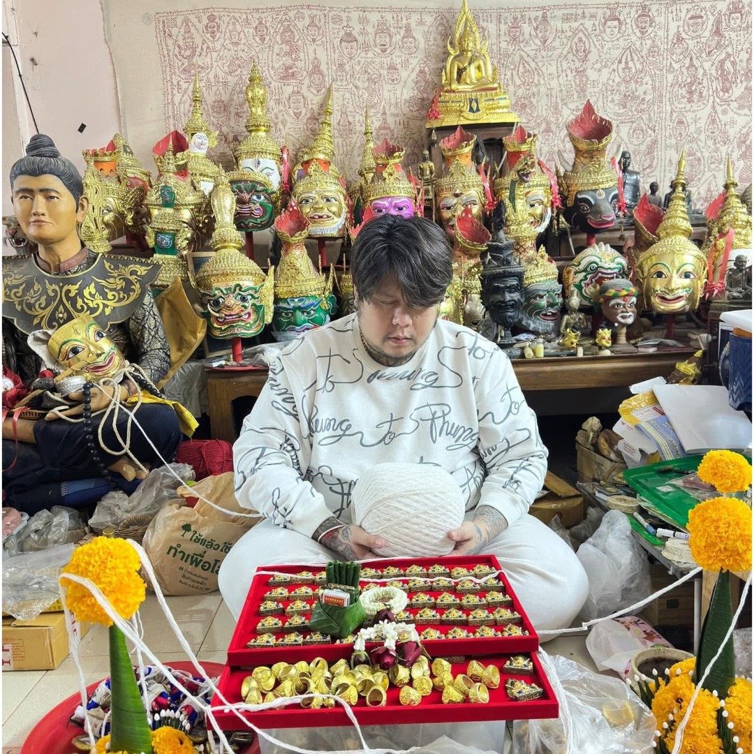 Ajarn Nut consecrating the Khun Paen Saneh Nuea Duang batch with sacred thread, offerings and trays of amulets