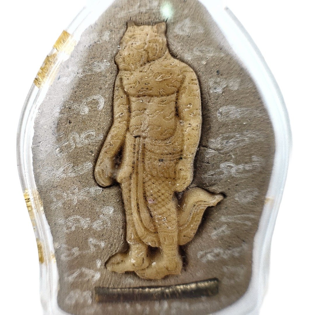 Close-up of the carved Lersi Sermingpai figure, surrounding hand-engraved yants and takrut on the back of the clear-cased amulet.