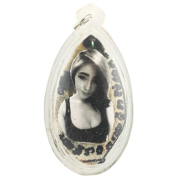 Front of the Mae Oyy Amulet featuring her black-and-white portrait, sacred inscriptions and clear protective casing.