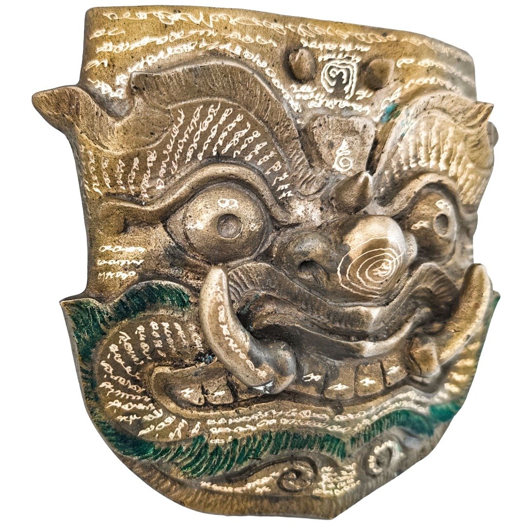 Side angle of Ajarn Kitkamo Phaya Purisat Phi Lu mask showing hand-engraved yants and fierce yak features