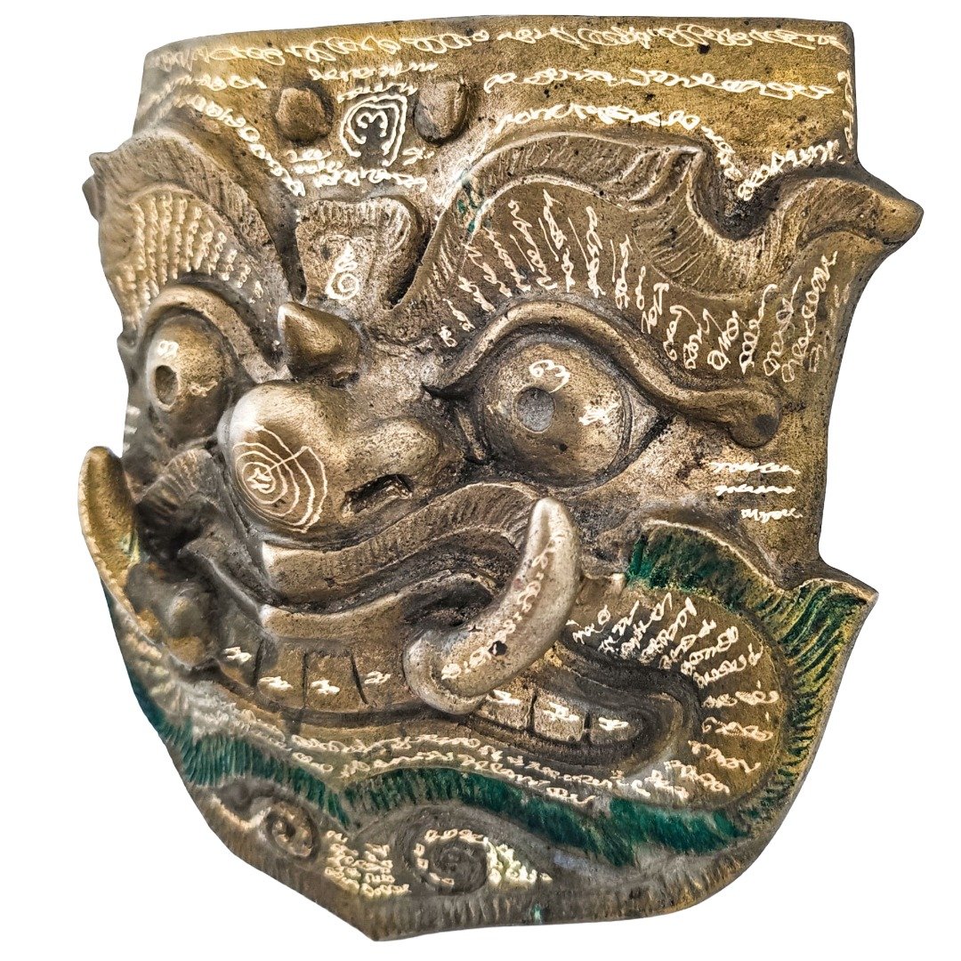 Angled front view of Phaya Purisat Phi Lu mask by Ajarn Kitkamo with hand-engraved yants across the surface