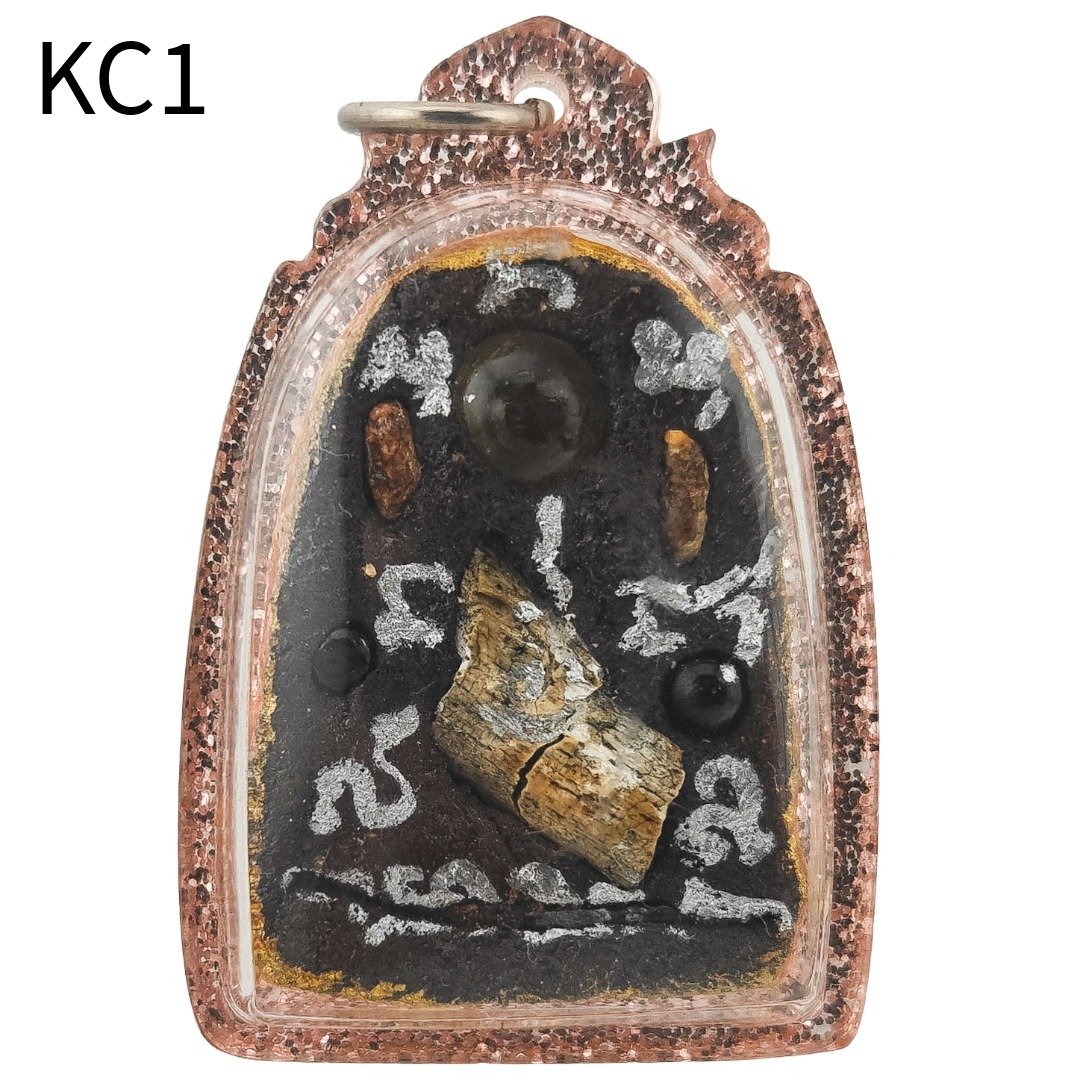 Back of the Khun Chang amulet showing fossilized rice relic, coffin nail, gradook fragment, crystals and sacred inscription.