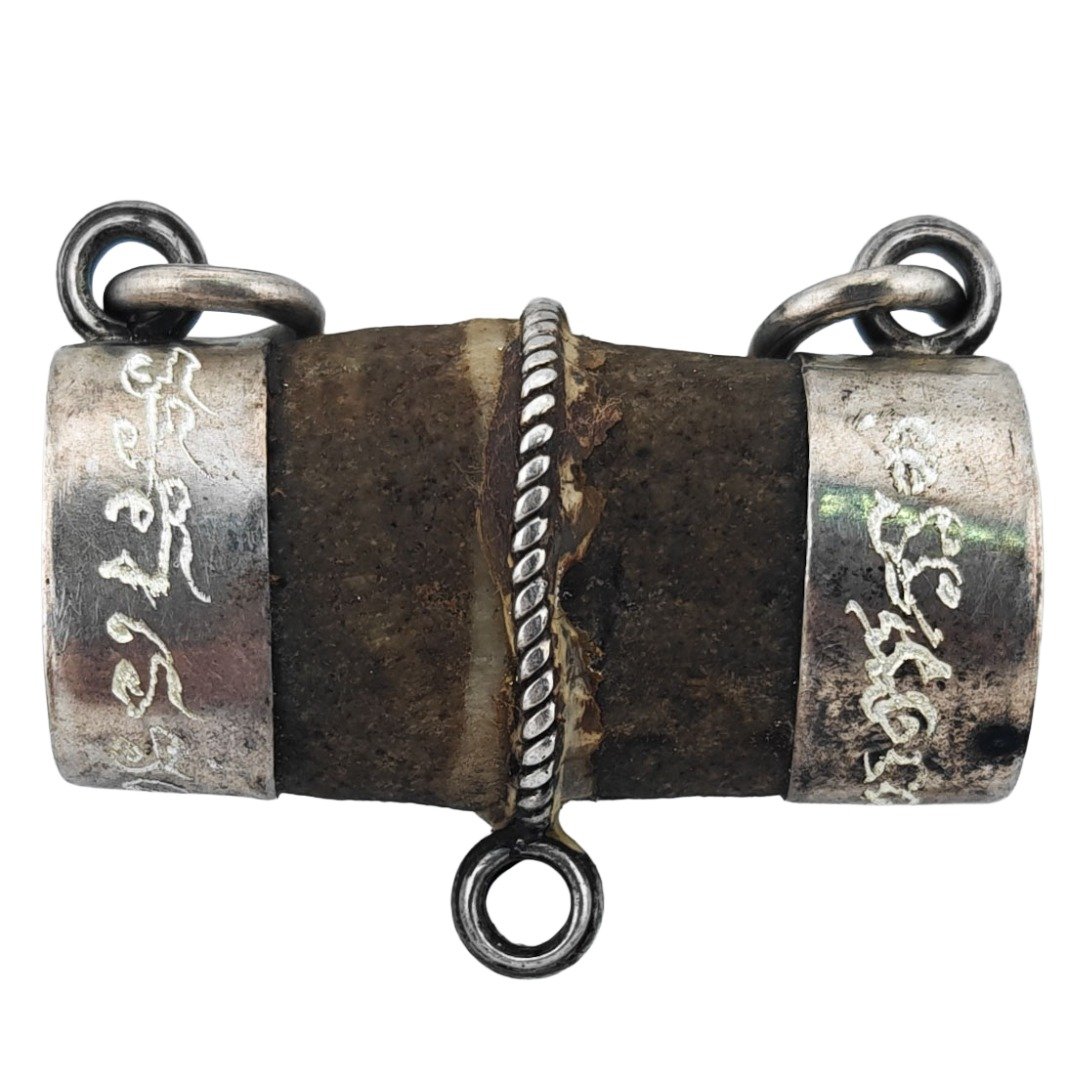 Side view of the Bird’s Golden Pillow showing the aged natural talisman enclosed within Phu Lersi Pong’s hand-yanted real silver casing