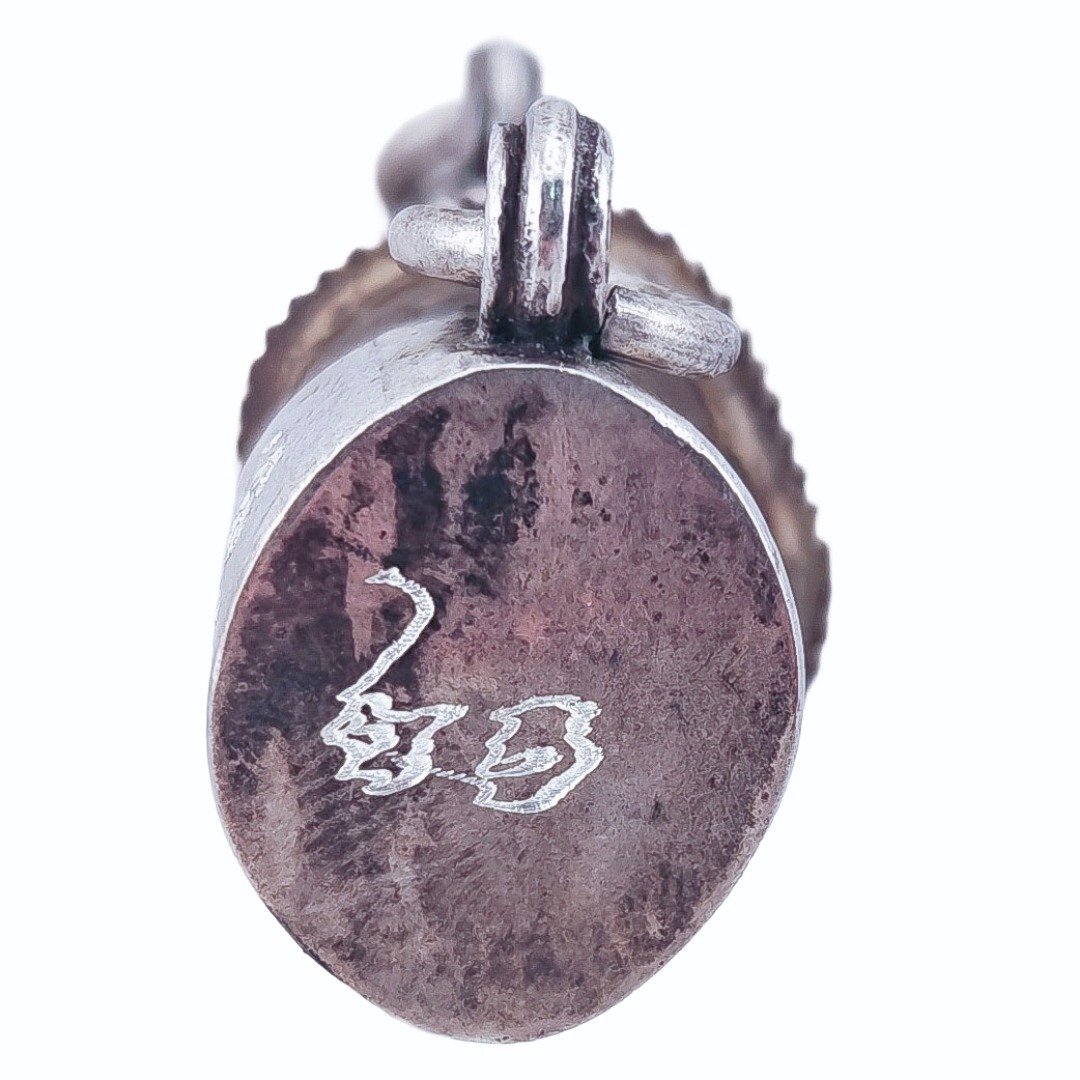 Close-up of hand-yanted characters on one end of the real silver casing of the Bird’s Golden Pillow