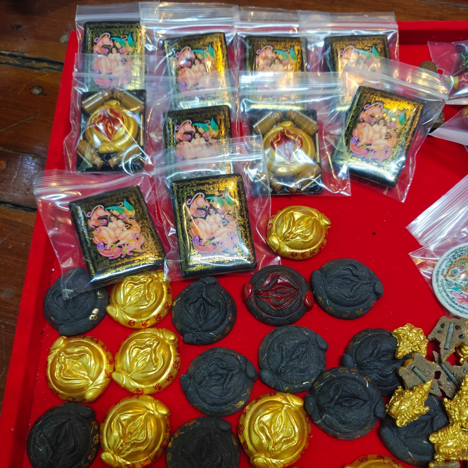 Batch of Dao Lom Deun VIP Locket pieces by Kruba Thep showing Mae Per and Phet Payathorn fronts together with the Yoni amulets
