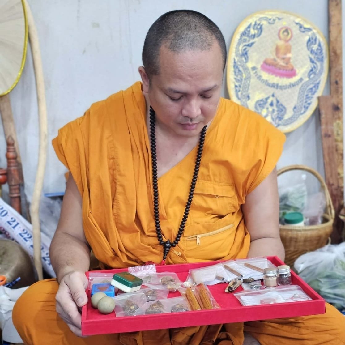 Kruba Chokchai at Wat Nam Dib with sacred objects and amulets from his line