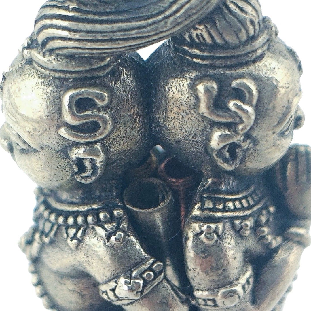 Close-up of sacred characters on the twin Kumantong heads, with the hollow takrut between them.
