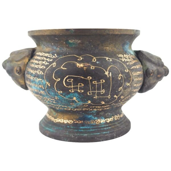 Full view of a prominent circular yant engraved between the two animal-head handles of the old samrit incense urn