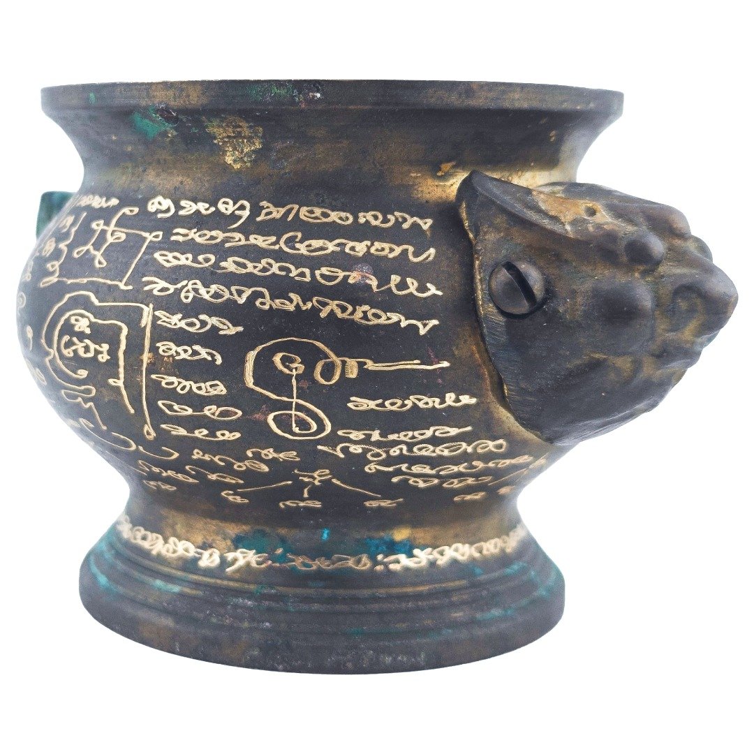 Detailed side view showing Ajarn Kitkamo's engraved yants beside the animal-head handle