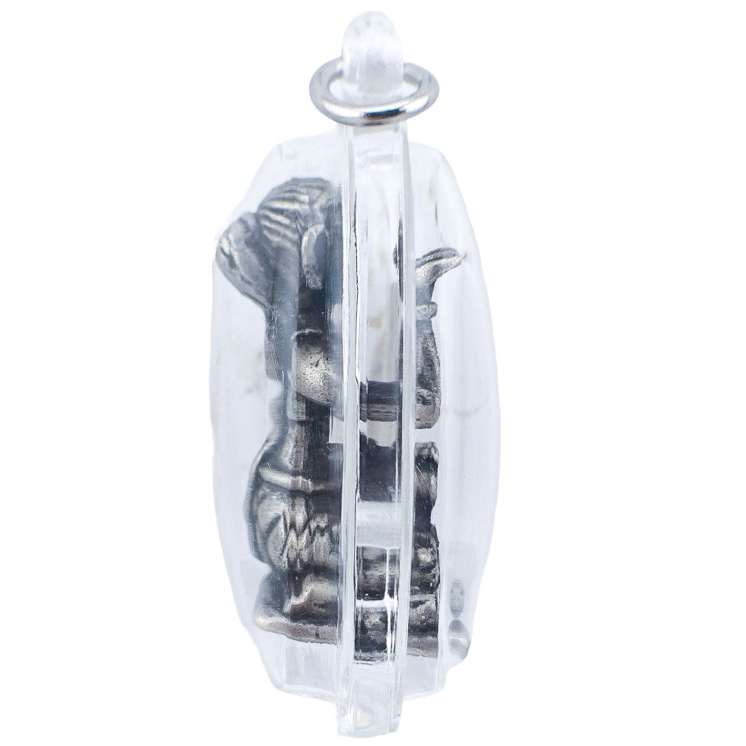 Side profile of Forgotten Nang Kwak showing the raised beckoning hand, figure thickness and details inside the transparent casing.