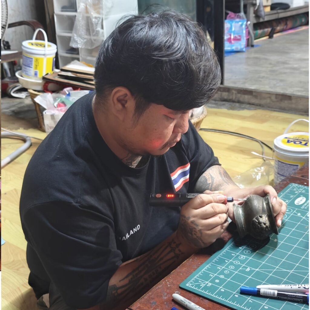 Ajarn Kitkamo personally engraving sacred yants onto the old samrit incense urn