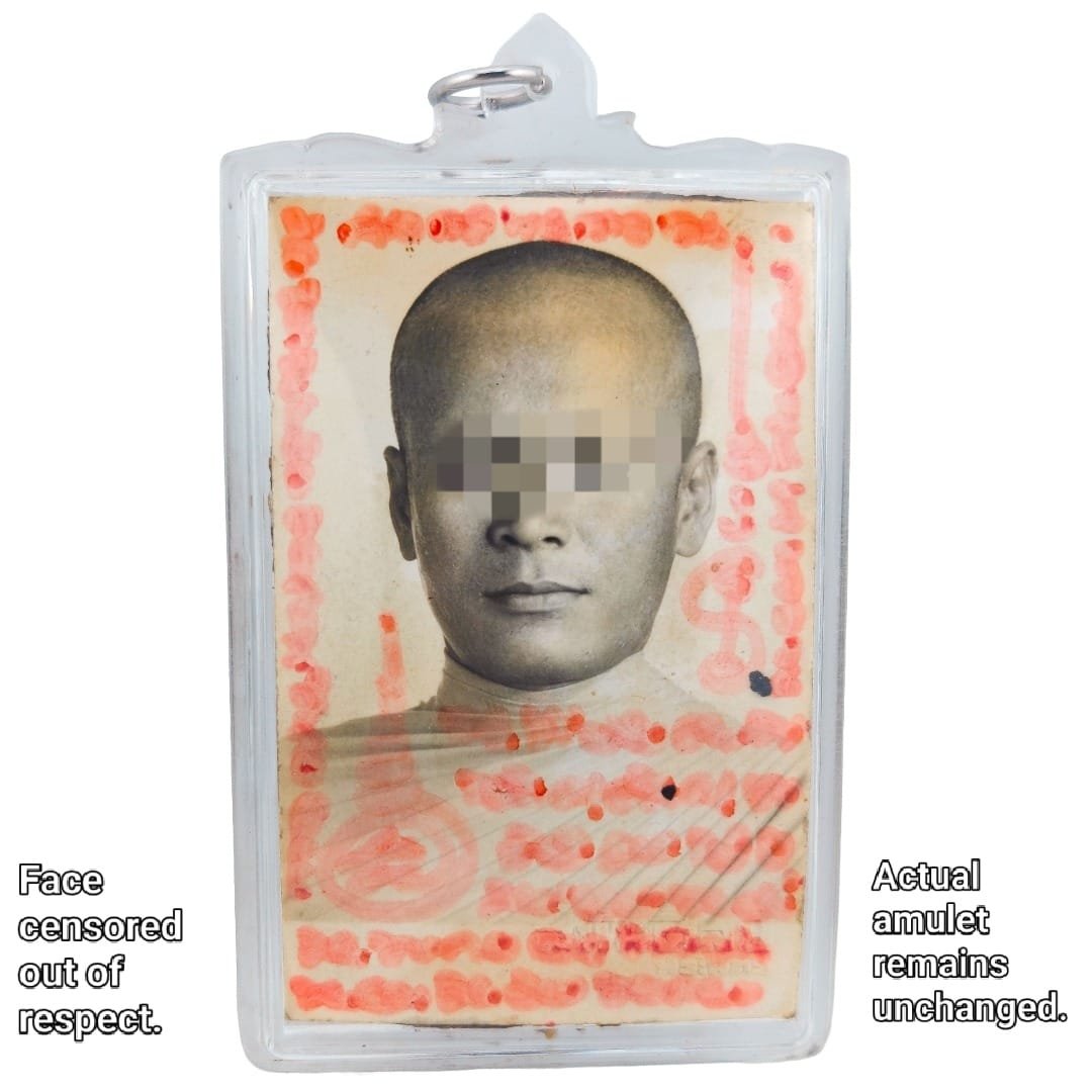 Front of the one-to-one Nameless Monk Prai amulet with the monk's portrait, red handwritten yants and face censored out of respect.