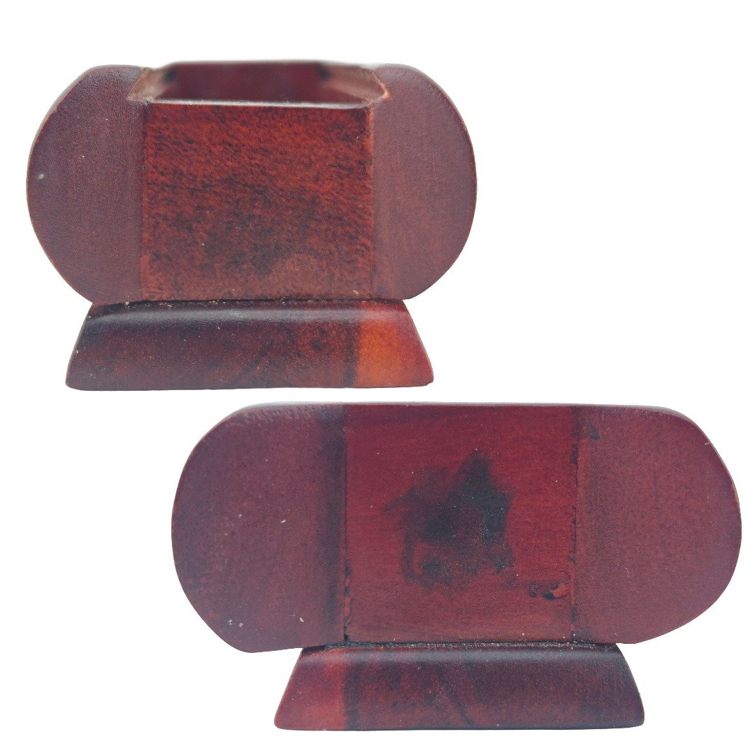 Two exterior views of the red wooden Mao Shan Vampire Coffin showing its curved shape, wood grain and surface details.