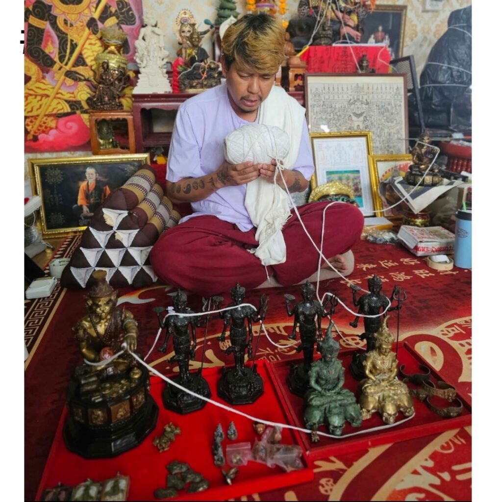 Ajarn Wut blessing the Nine-Tail Fox Samrit amulet alongside other pieces at his samnak before we brought them back
