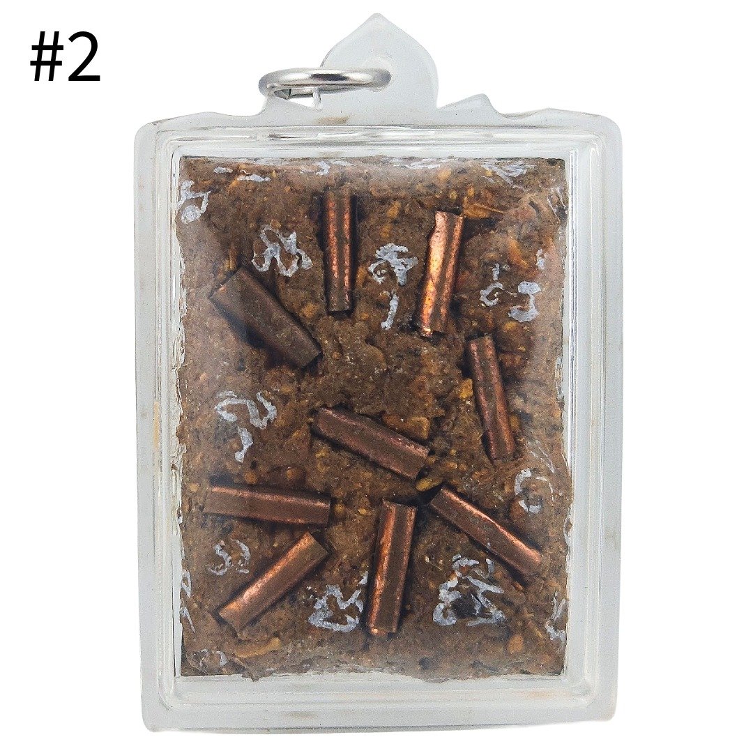 Tamlar Eating Bug Locket piece 2 showing brown amulet surface with copper-coloured metal inserts and white inscriptions.