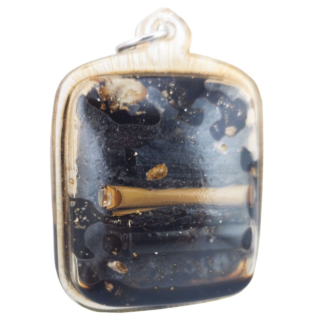 Angled rear view of Ajarn Tay's Panneng Ngan showing two takruts and embedded prai materials inside the oil casing.