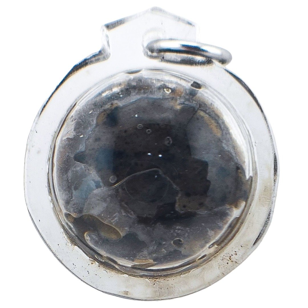 Front close-up of a Pure Hakom Wax Luk Om by Ajarn Tom, showing the dark concentrated Hakom Hua Chuea inside its clear round casing.