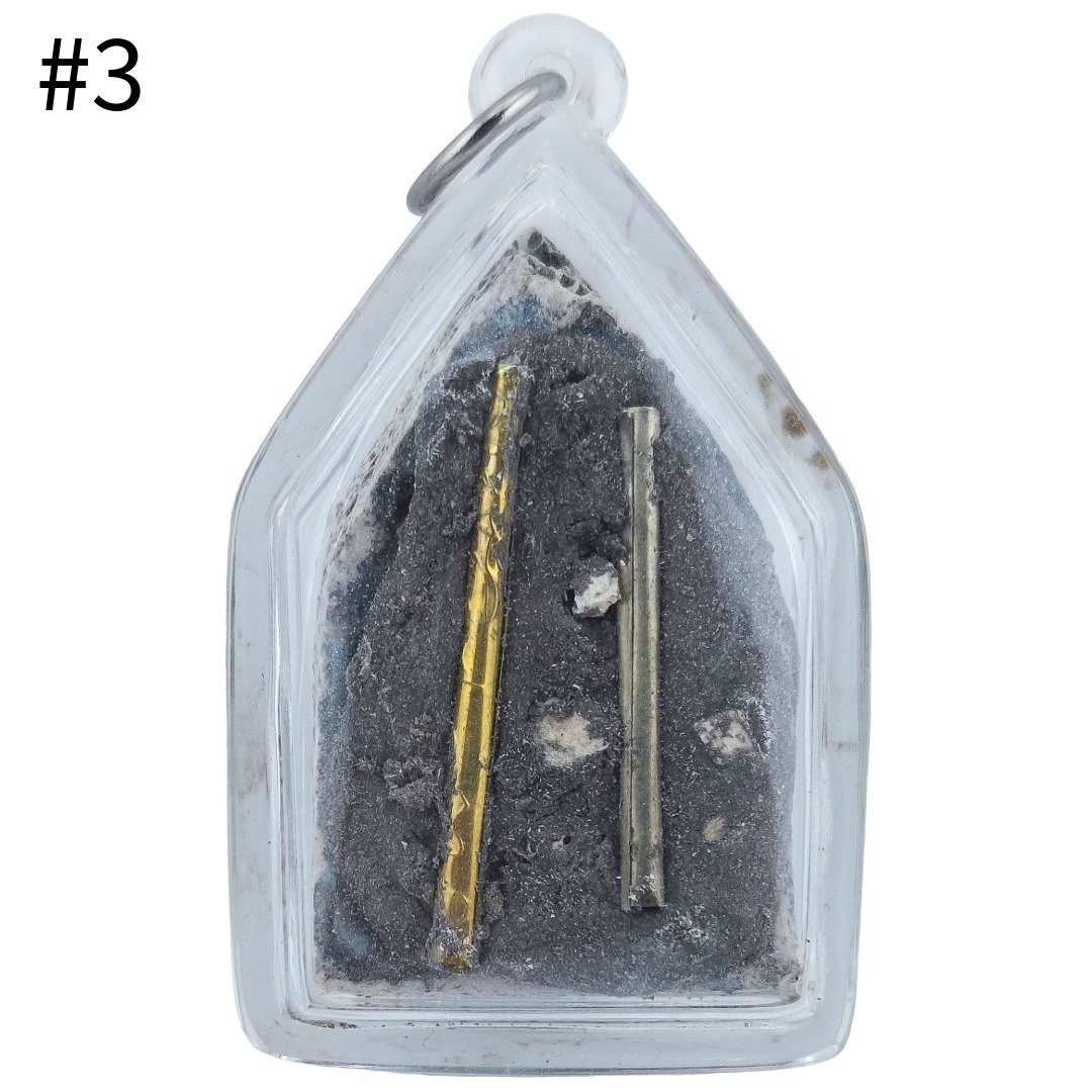 Back of Gradook Prai Khun Paen piece 3 showing two metal takrut and patches of lighter material within the dark murn sarn, without yants