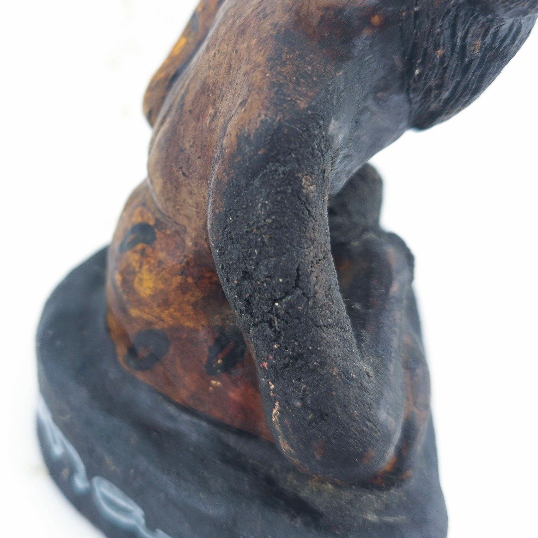 Close-up of the arm and shoulder of Ajarn Tom's old Lersi Sermingpai Bucha, showing rough surface texture, wear and signs of repair.