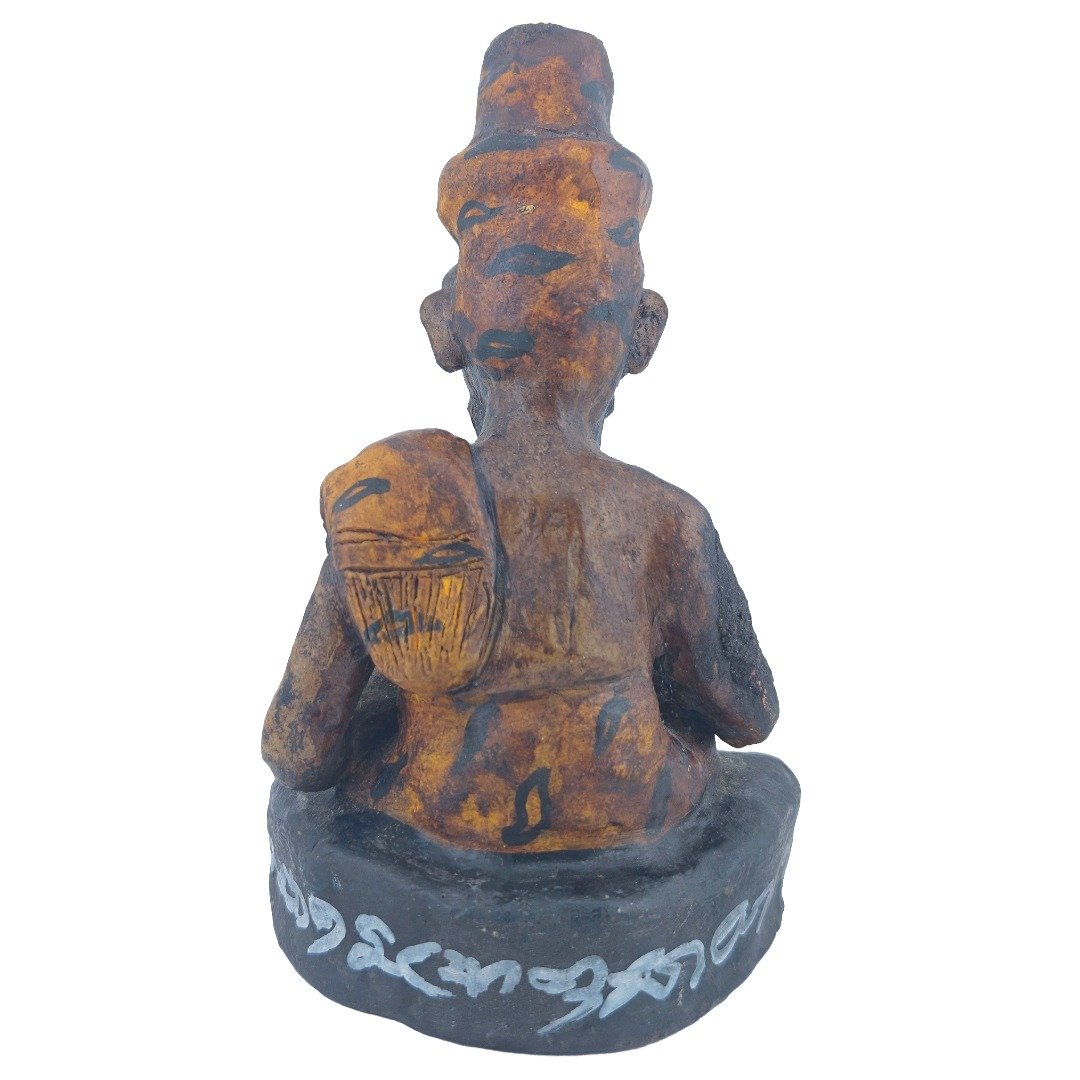 Rear view of Ajarn Tom's old Lersi Sermingpai Bucha showing the back of the ascetic, shoulder ornament, aged surface and white inscriptions around the base.